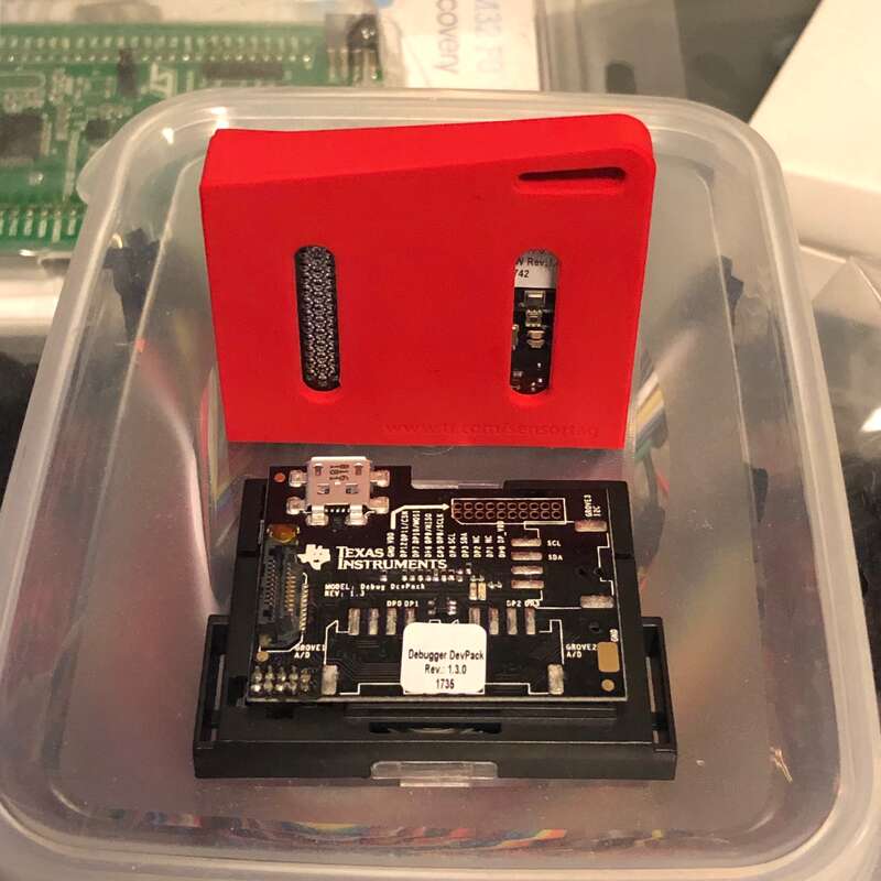 Two SensorTags. One with it’s red rubberised case removed and debugger board attached.
