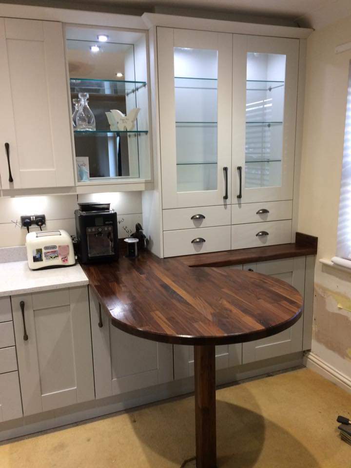 A seating area in the kitchen is so important to most of our clients, like this handcrafted 4cm thick American Walnut curved breakfast bar, mirror backed display cabinet and matching clear glass dresser with LED lighting from <a href="/Sensio_Ltd/">Sensio Ltd</a>