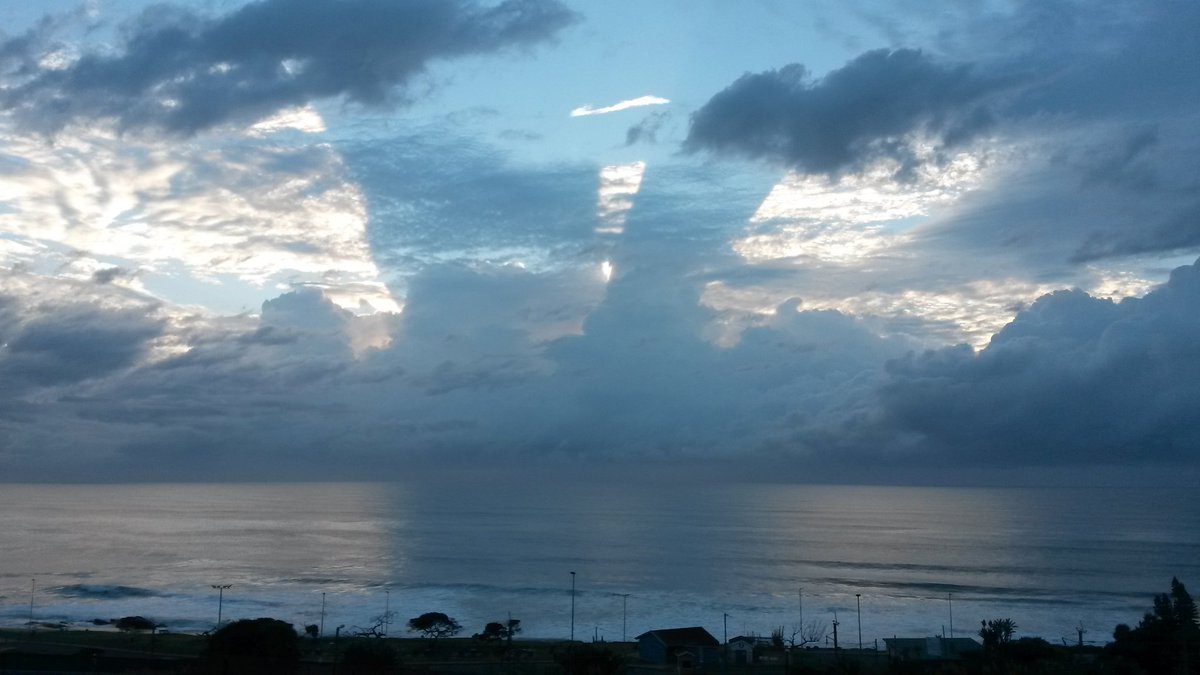 CathleenBraam's tweet photo. What on earth could cause such a shadow in the sky behind those clouds and on the ocean? https://t.co/LW5ivTvrES