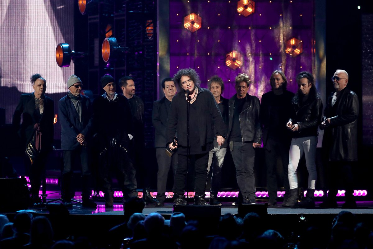 UltClassicRock's tweet image. Now *this* is quite a photo: It's Robert Smith accepting @thecure's @rockhall induction, flanked by so many of his current and past bandmates. Poignant. &amp;lt;3 #RockHall2019