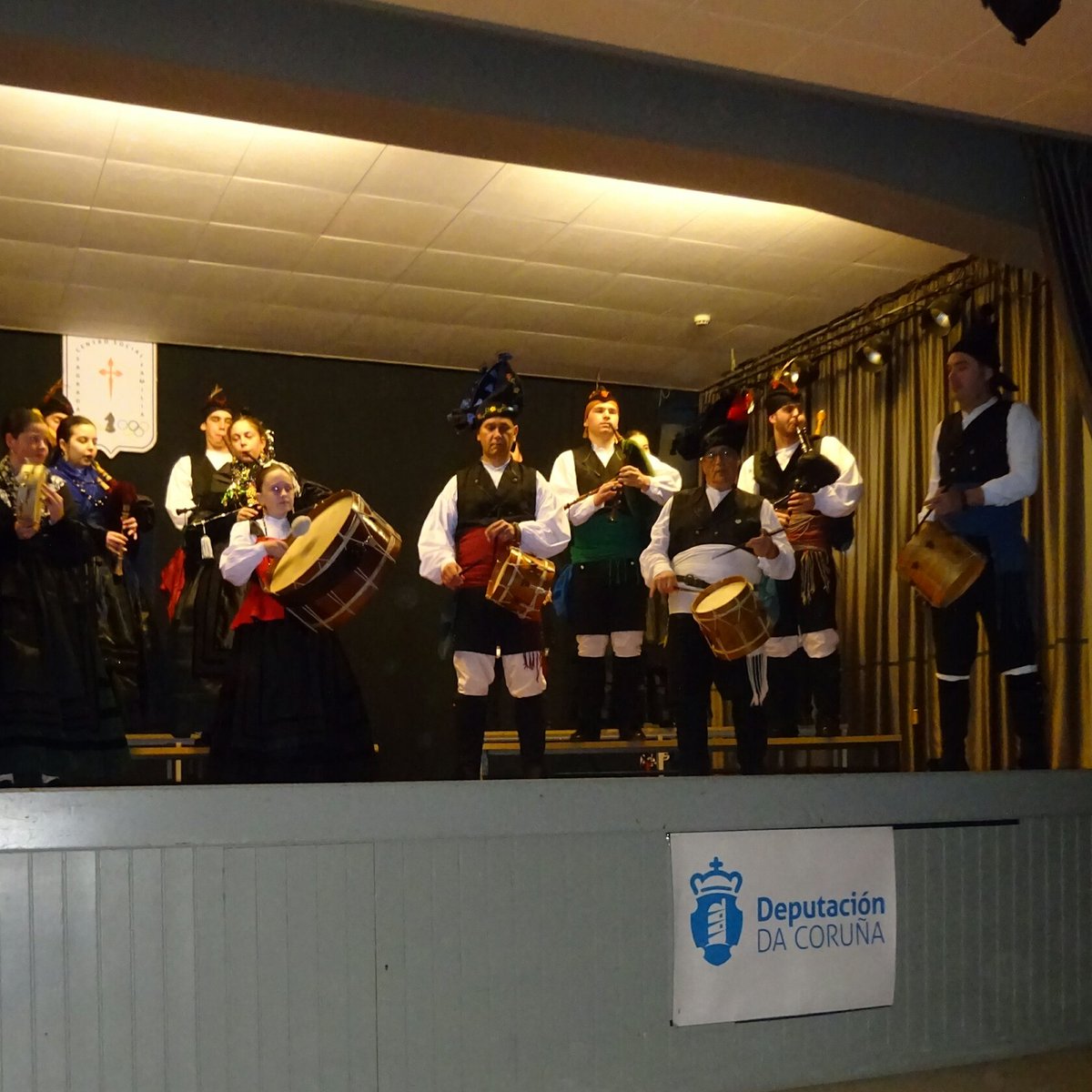 Arre_Demo's tweet photo. Actuando agora mesmo a formidable Banda de Gaitas de #Queiroa de #Sada no salón de actos do Centro Social Sagrada Familia en #ACoruña. https://t.co/5zZZjSFkye