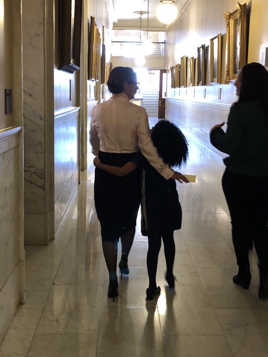 EBB_RI's tweet photo. After being introduced as @GovRaimondo pick for Ed Commissioner @AInfanteGreen walks down State House corridor w/daughter Aiyana https://t.co/7rrlKRd32p