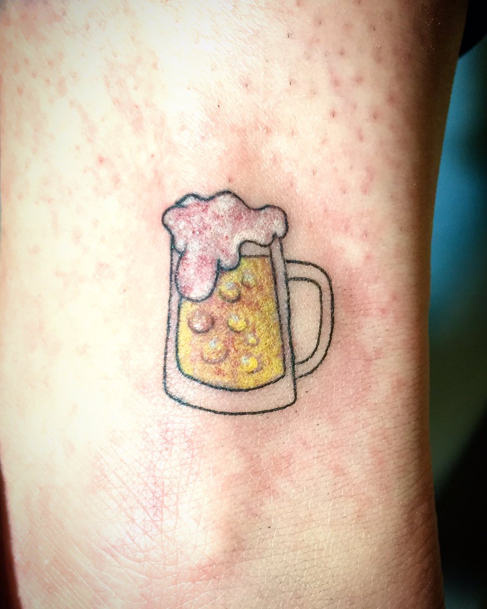 Premium Photo  Tattooed hand holding a beer glass at a party