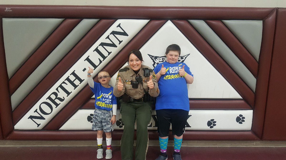 LinnIASheriff's tweet photo. SRO Deputy Hughes was at @NorthLinnLynx today to celebrate #WorldDownSyndromeDay. James and Kasyn gave all the students and teachers two thumbs up for doing a Down right awesome job! 👍🧦 https://t.co/W53aUV7Ef0
