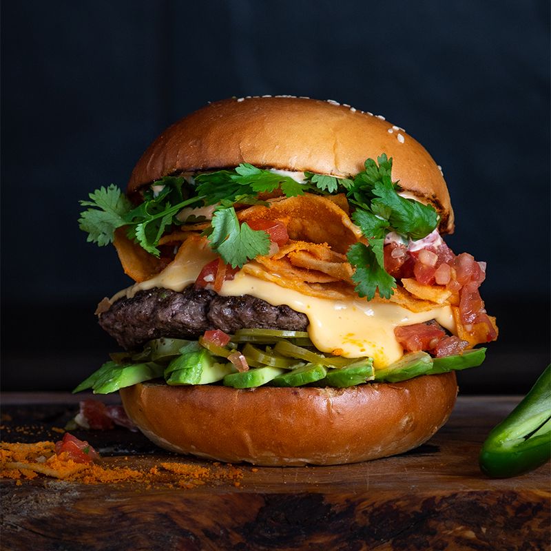 TwitCoast's tweet photo. Muy caliente! @TacoLinas 's "The Nacho Burger" made with Getaway Farms beef, topped with queso cheese sauce, avocado, pico de gallo, pickled jalapeño, crushed housemade ‘doritos' and spicy mayo. $14. 2605 Agricola Street. https://t.co/tStmwFnDvW