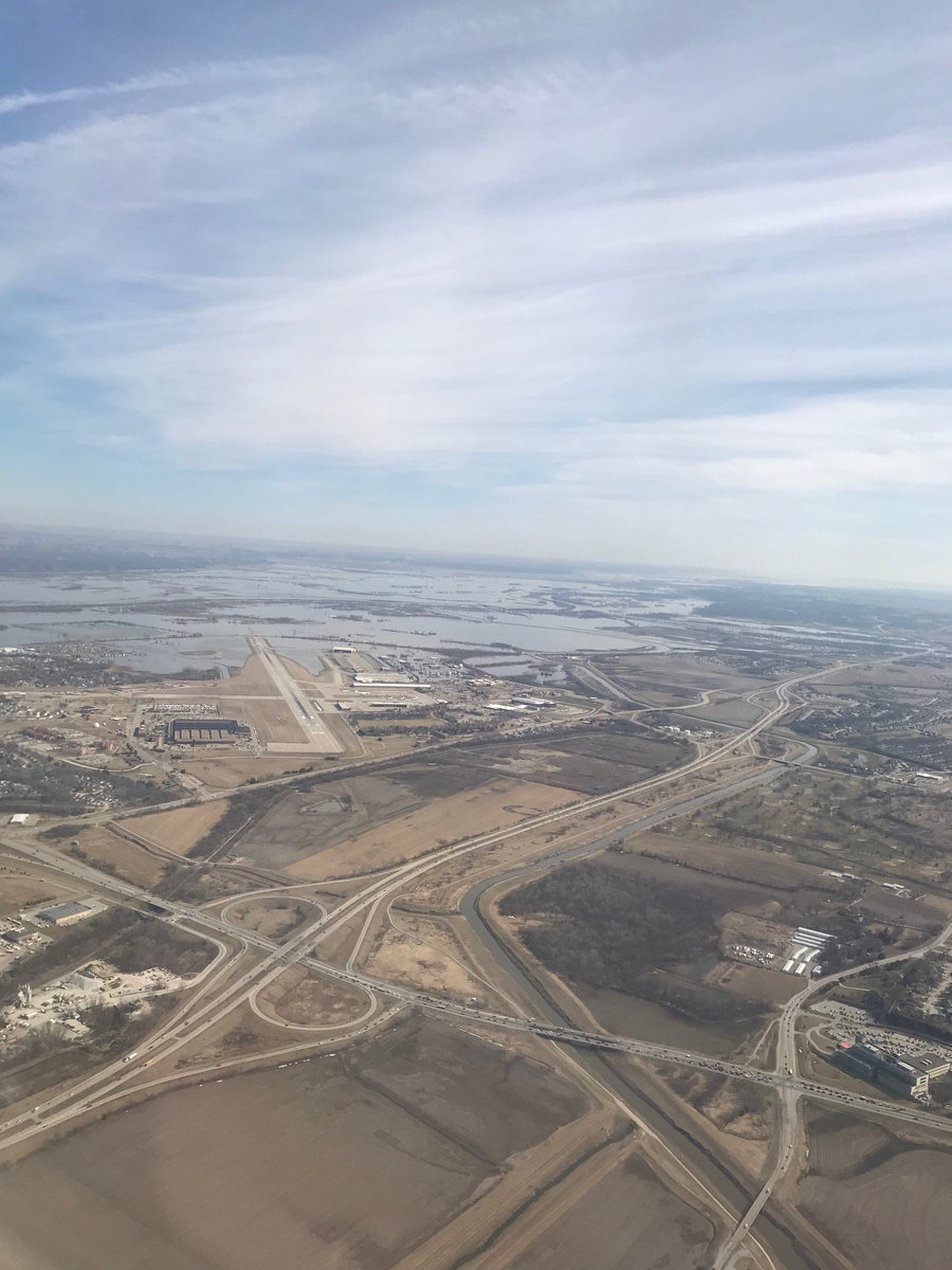 WaterWired's tweet photo. Photos from @united 529 on approach to @OMAairport over Bellevue, NE. LHS: @Offutt_AFB runway plunging into Missouri River; Iowa in background, RHS: looking north along river. Downtown Omaha dry. cc: @sejorg @oregonstategeog @AWRAHQ @AWRACO @LISABEUTLER @theAAG @OSUCEOAS @USACEHQ https://t.co/vpFnU5Ooe3