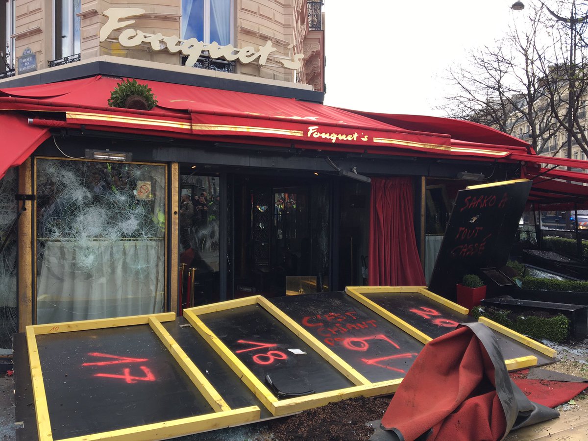 Et voici le Fouquet’s... Sans doute le plus impressionnant avec des panneaux de métal soudés les uns aux autres. Même l’enseigne du restaurant a disparu. Il a été saccagé la semaine passée (seconde photo) puis a brûlé.