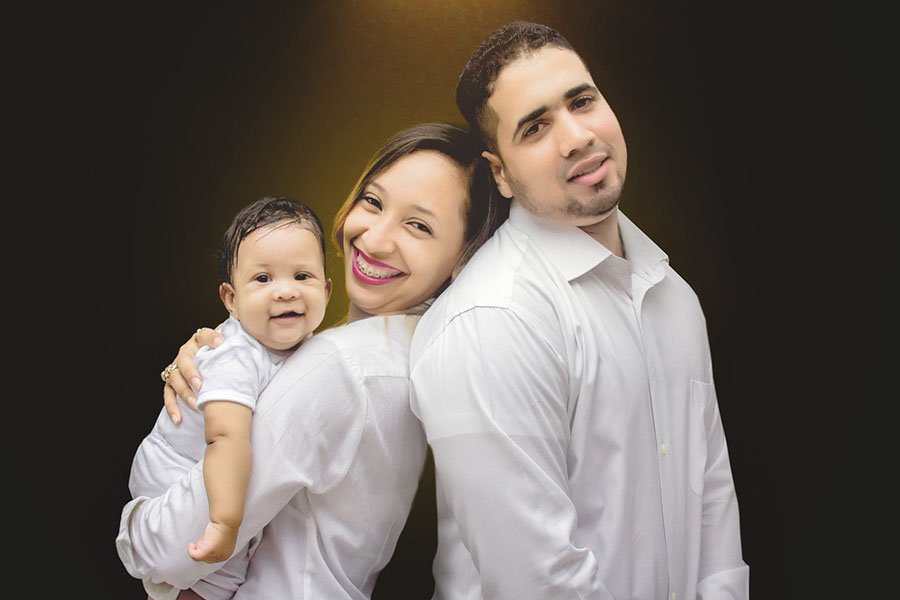 a photo of a man, woman and baby smiling