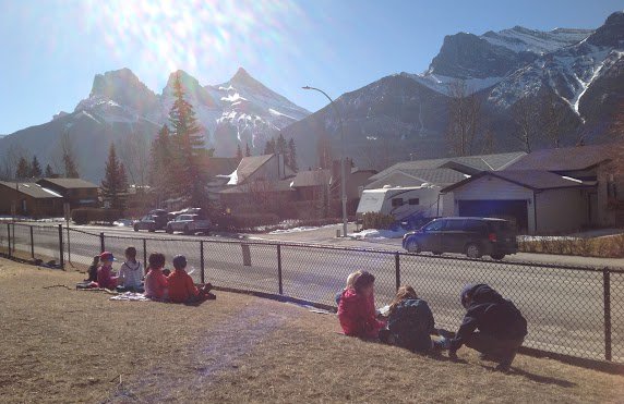 MmeAnnaW's tweet photo. Kindergarten and grade 2 buddies reading together in the sunshine.  Spring is in the air! @ers_school @MountainEdu https://t.co/iddvgnRCCJ
