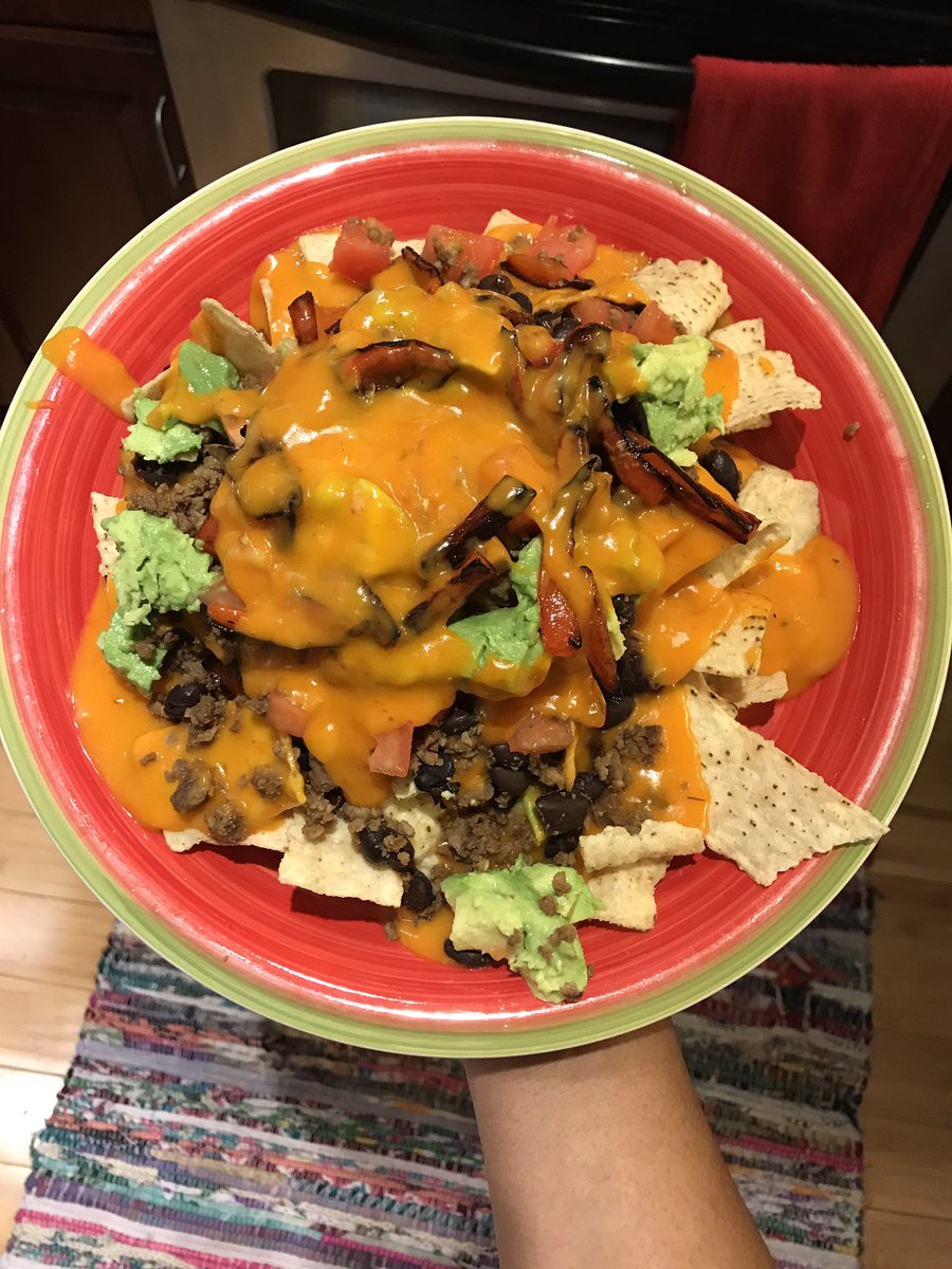 Buffalo Cheese Nachos with roasted red peppers, tomatoes, avocado, black beans, vegan beef crumbles and avocado 