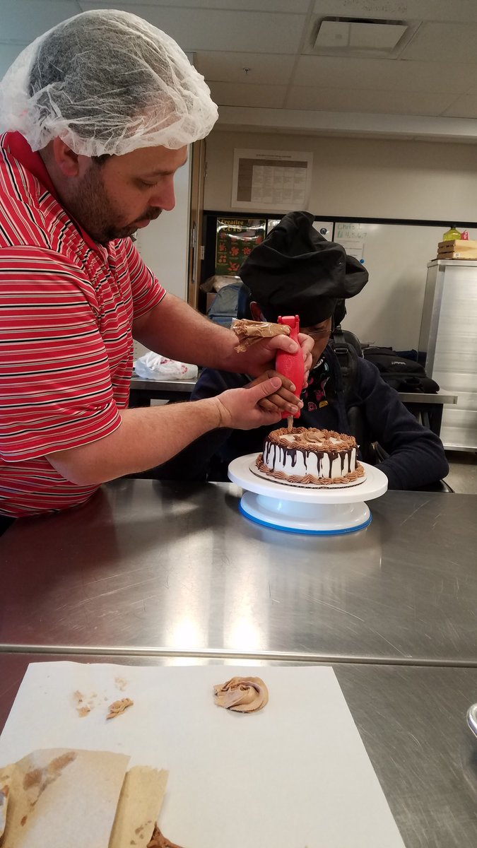 Chef_Polk_24's tweet photo. A favorite part of teaching is when you have to get creative to help a student to be successful.  I helped a student to be able to ice a cake by designing a custom device and printing it on a 3D printer.  With the help of his aide, he was able to decorate a cake.@BillHarner https://t.co/nEs2MxZh3Z