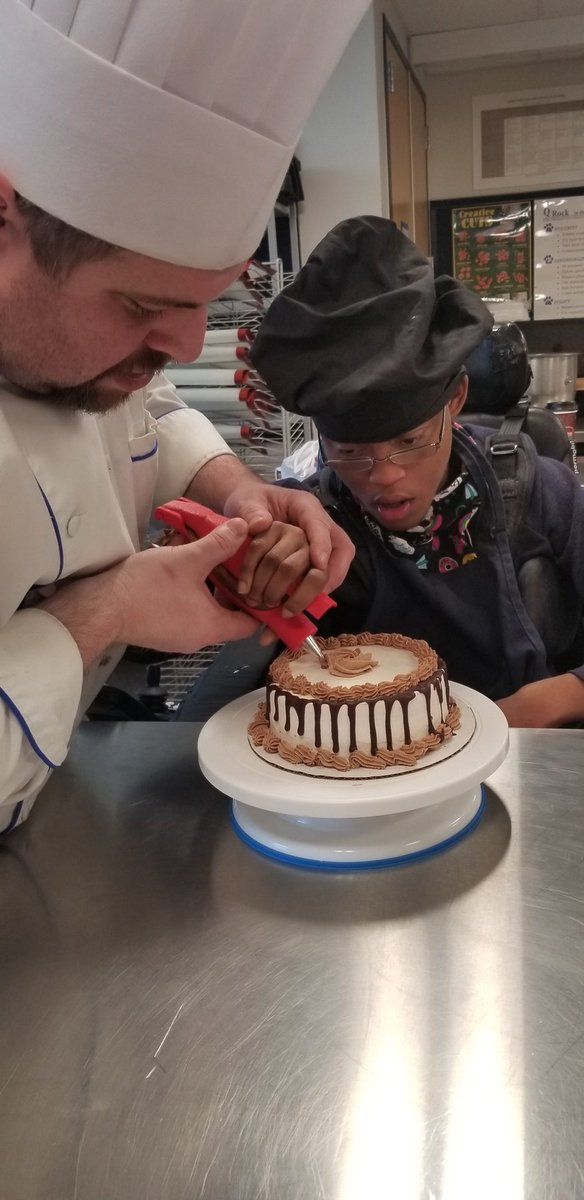 Chef_Polk_24's tweet photo. A favorite part of teaching is when you have to get creative to help a student to be successful.  I helped a student to be able to ice a cake by designing a custom device and printing it on a 3D printer.  With the help of his aide, he was able to decorate a cake.@BillHarner https://t.co/nEs2MxZh3Z