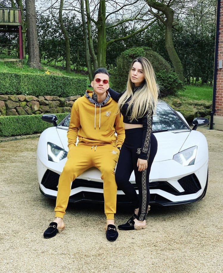 hostiamendi's tweet photo. My keeper sits on the bonnet of his 19 plate Lamborghini with his 10/10 wife. What does yours do? https://t.co/N9qMSOlpuT