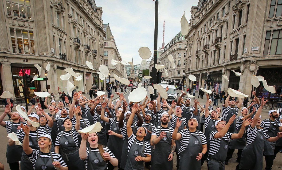 PizzaExpress's tweet photo. Check out our awesome Pizzaiolos in the West End this morning! To mark the re-opening of our new sociable pizzeria in Langham Place, Oxford Circus, 54 pizzaiolos (one for every year of PizzaExpress) were showing off what we’re famous for 🍕🍕🍕🍕🍕

#PizzaExpressFlareMob https://t.co/xW4EXXStxN