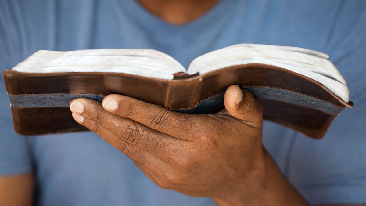 Person holding a book of scripture