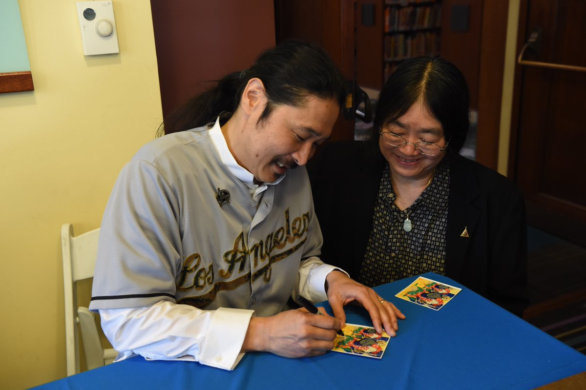 man signing card for woman