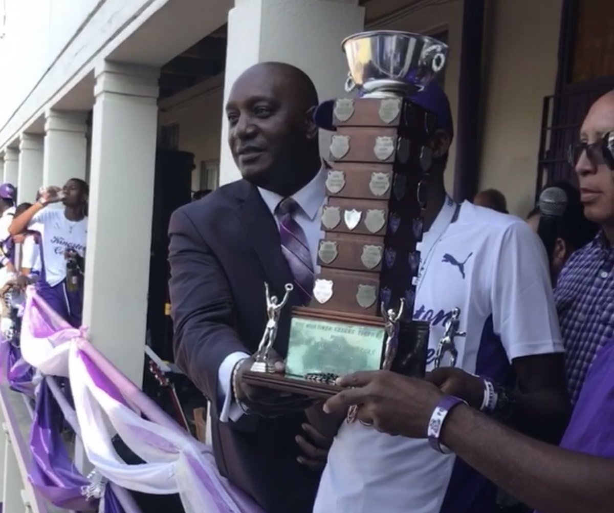 firstglobalbank's tweet photo. Principal of Kingston College, Dave Myrie smiles with the 2019 ISSA Grace Kennedy Boys' Champion trophy! #FGBChargeUp #GKChamps #PoweredByFGBAffinityCard #ChargeUpYourSchoolSpirit #Champs2019 https://t.co/WqCKDOeqng