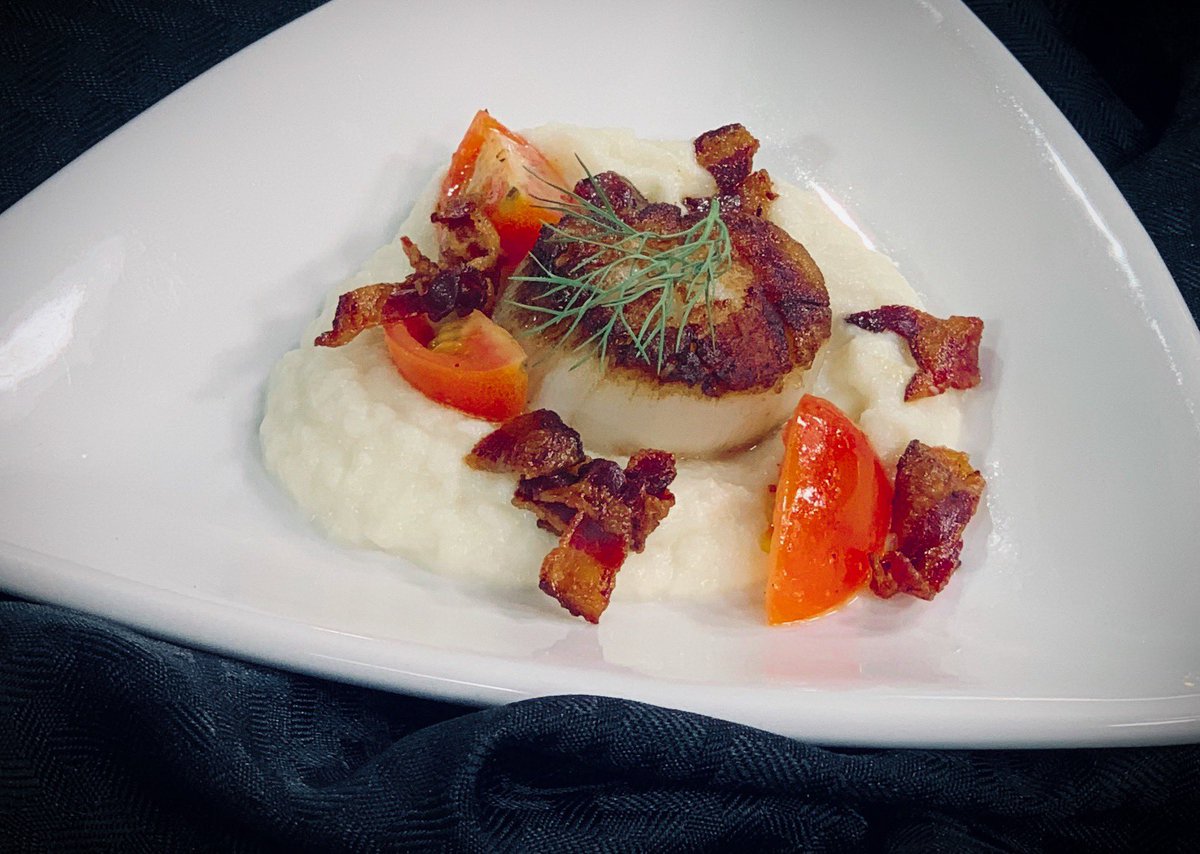 Seared scallops served with puree of cauliflower, cherry tomatoes and bacon bites. The main course for our April Prix Fixe Dinner on April 25-27th. For full menu and reservations, visit : 
exploretock.com/thecatererskit…