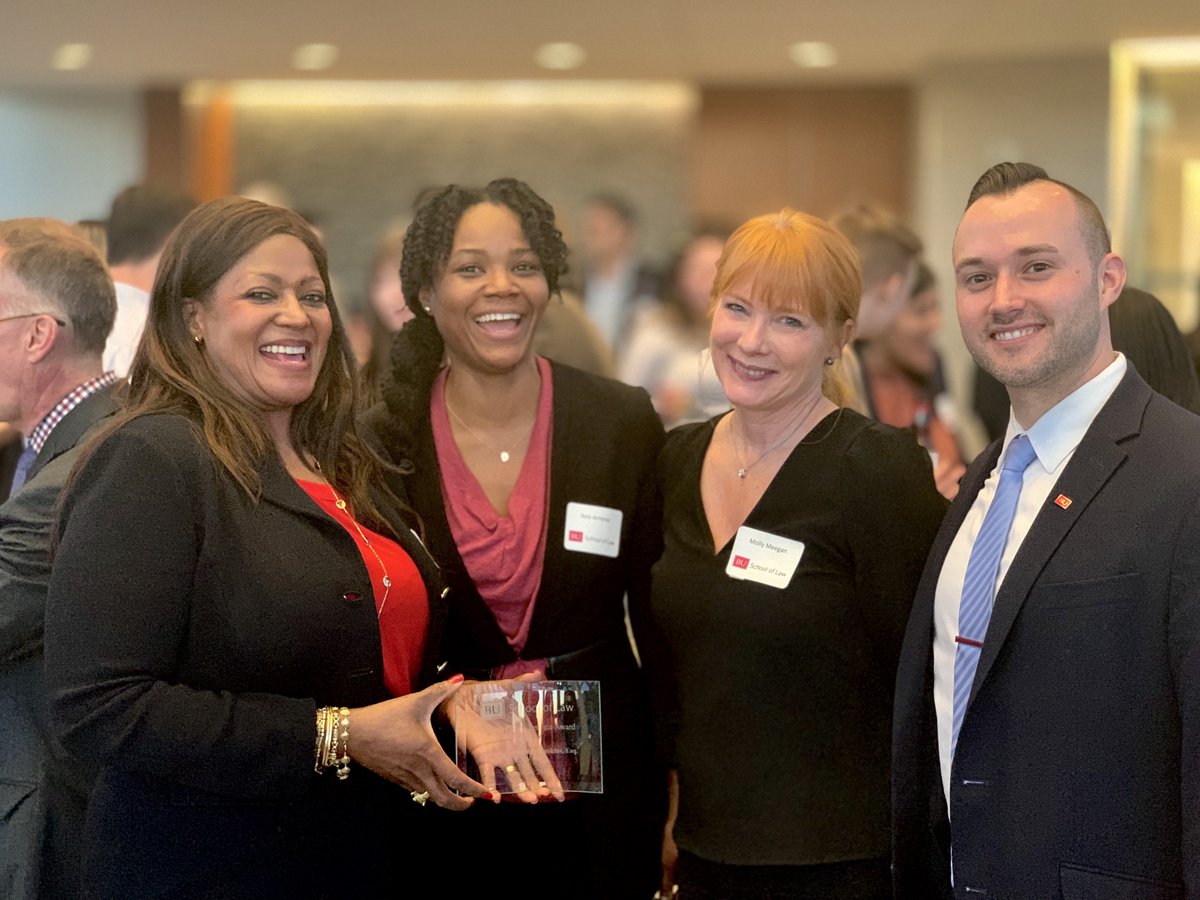 Nicole Greenidge-Hoskins with colleagues, holding BU Law award