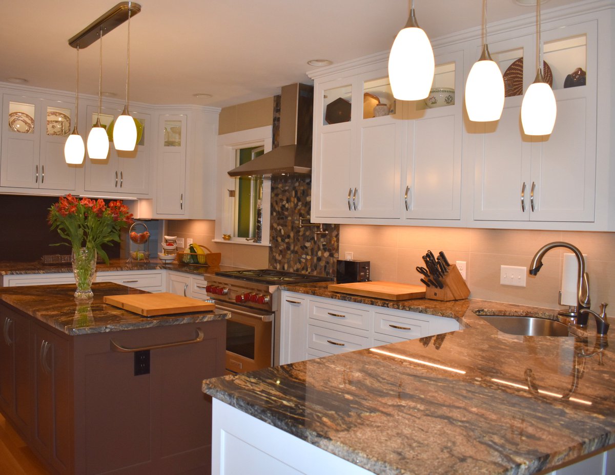 CoolidgeCompany's tweet photo. This elegant kitchen features glass doors with cabinet lighting, exquisite granite countertops that enhance the different cabinet colors, and a ceramic tile chimney at the gas stove. (Rye, NH) https://t.co/pQjKquR2VW