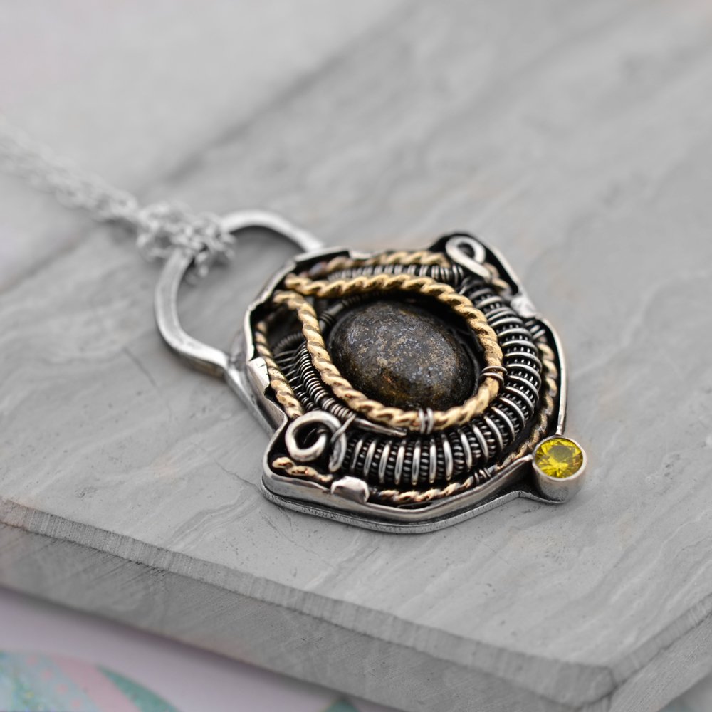 WireWrapGuide's tweet photo. Small silver casing with inlay of sterling silver and goldfill wirewrap. A pyrite in the middle and citrine under it. First time i tried something like this. (by me) #wirewrapped #wirewrap #jewelry #necklace #pendants #wrapsofig #handmade #wirewrapguide https://t.co/NqFV9nVQ3x