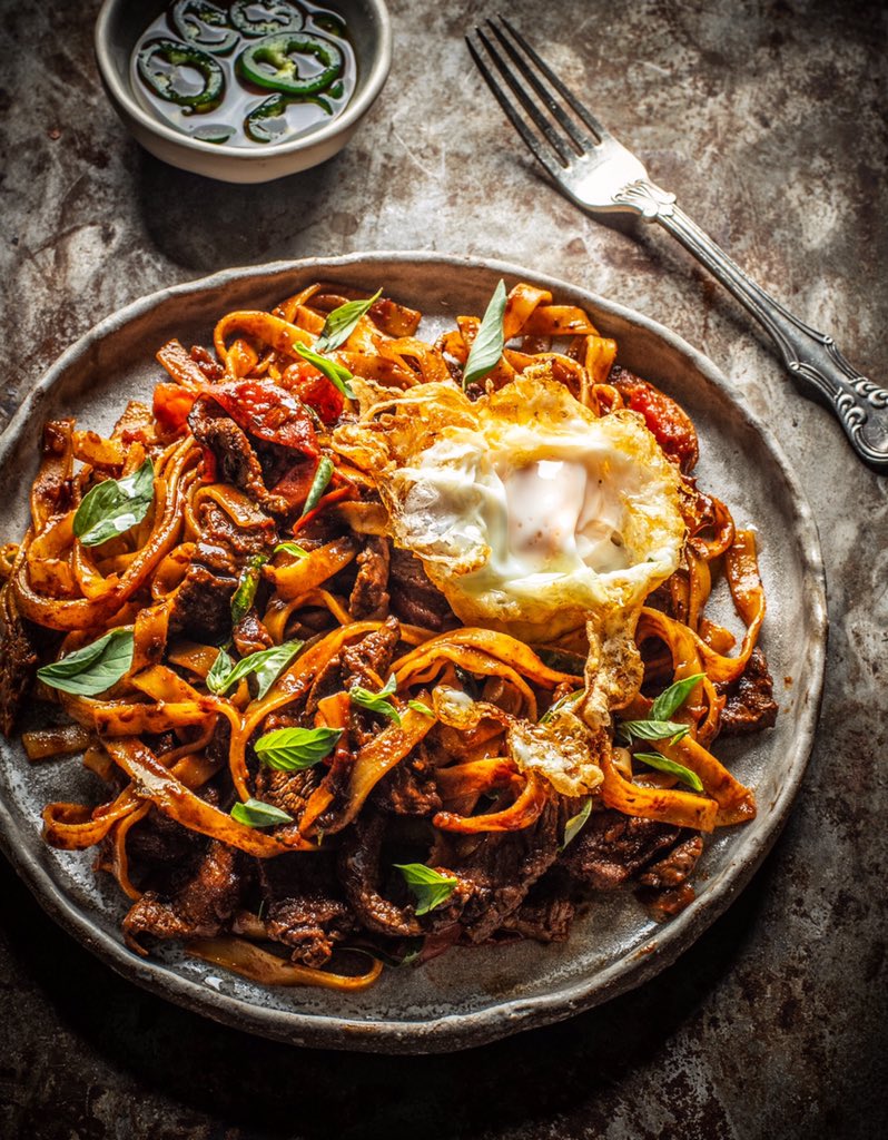 WeeRascal's tweet photo. Pad Kee Mao. Drunkard’s Noodles and a deep fried egg from ‘Baan’, the shiny new book I’ve been waiting for from a dear friend, @kplunketthogge. I’ve had the pleasure of eating her food and she is one of the most gifted cooks I’ve ever met. #FridayFeast #Noodles #Baan #Books https://t.co/FhHIUJwDXm