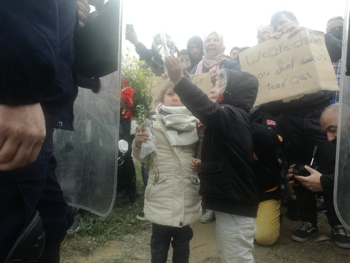 CostasKantouris's tweet photo. Two Afgani children give flowers to riot policemen in #Divata after clashes. But he didn't accept... #RefugeesGr https://t.co/Dy8HgKkaxN