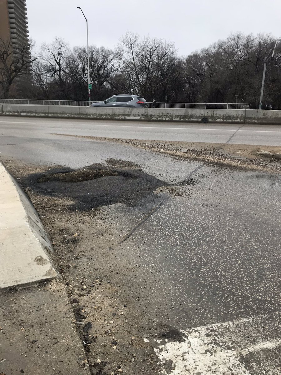 BethanyDaman's tweet photo. Hey @cityofwinnipeg, this hole has gotten a lot worse (Assiniboine/Osborne). Worried about the many cyclists who take this corner of everyday. @WpgBikeAlerts https://t.co/1JfTUM6Mn6