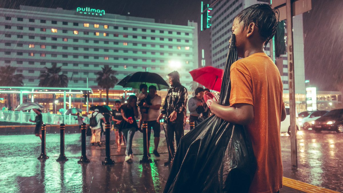 Buat gue, kedua foto ini adalah juxtapose. Ada anak kecil ojek payung yg sedang melihat anak kecil lain dipayungi bapaknya.