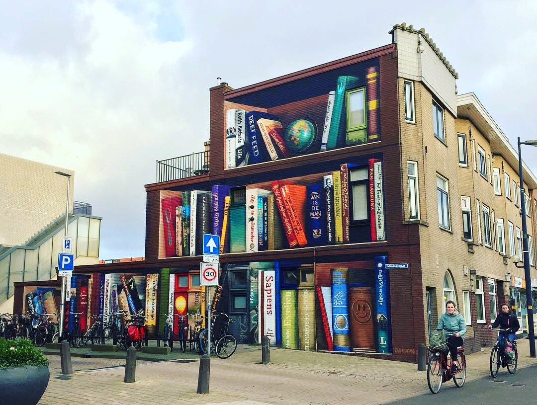 canalacultura's tweet photo. #Janisdeman y #DeefFeed son los encargados de crear este mural #literario de #TrompeLoeil en una vivienda de #Utrecht en #PaisesBajos, una estantería a gran escala de libros reales e #imaginarios que incitan a la #lectura en el mes de la #literatura+#libros+#idioma ... #streetart https://t.co/H15F2vi0SI