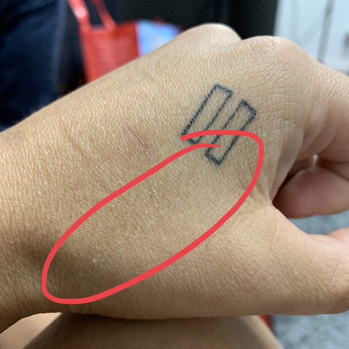 White ink cross tattoo on the finger.