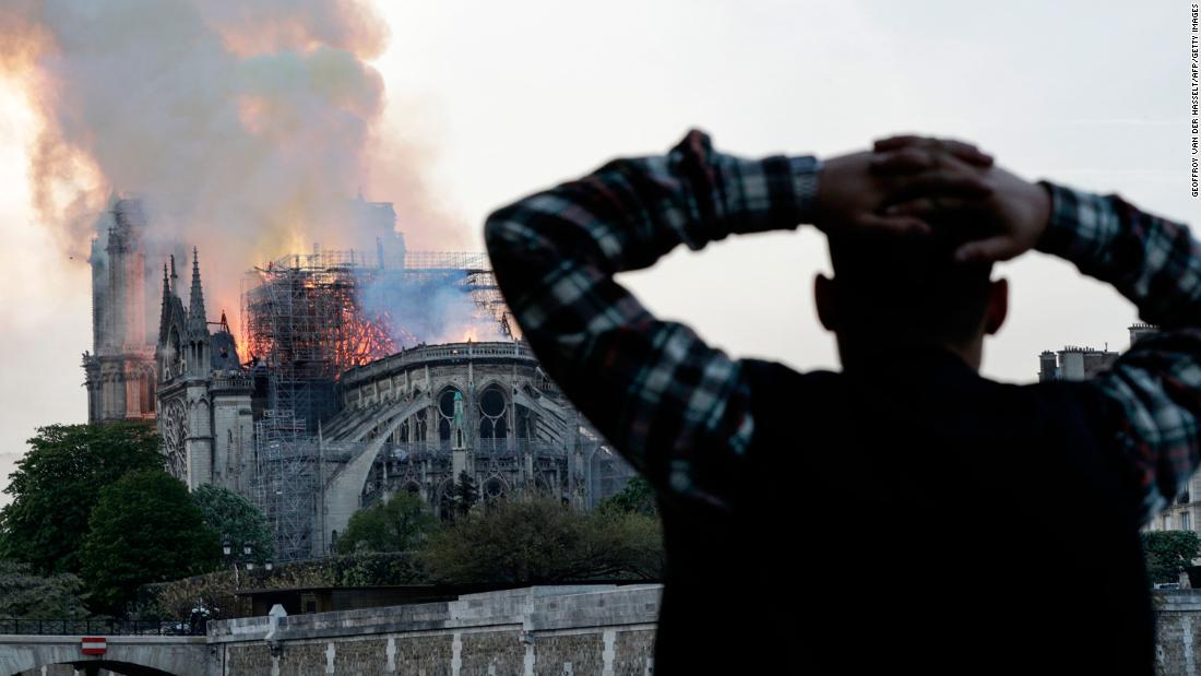 CNN's tweet photo. In Paris, people gathered in plazas and street corners, eyes trained on the all-consuming fire at the Notre Dame cathedral. The rest of the world gathered via screens big and small. United in helplessness. Unsure of what to say. But compelled to watch. https://t.co/hUmHF3Q3LC https://t.co/Wl6SmWEGIb