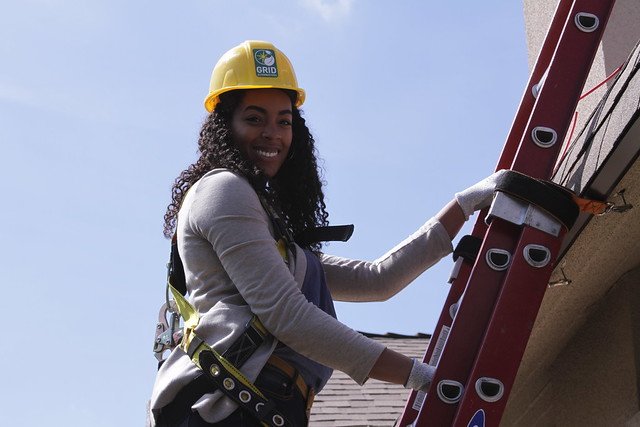 During a GRID solar installation sponsored by Tesla, staff get on the roof to volunteer!
