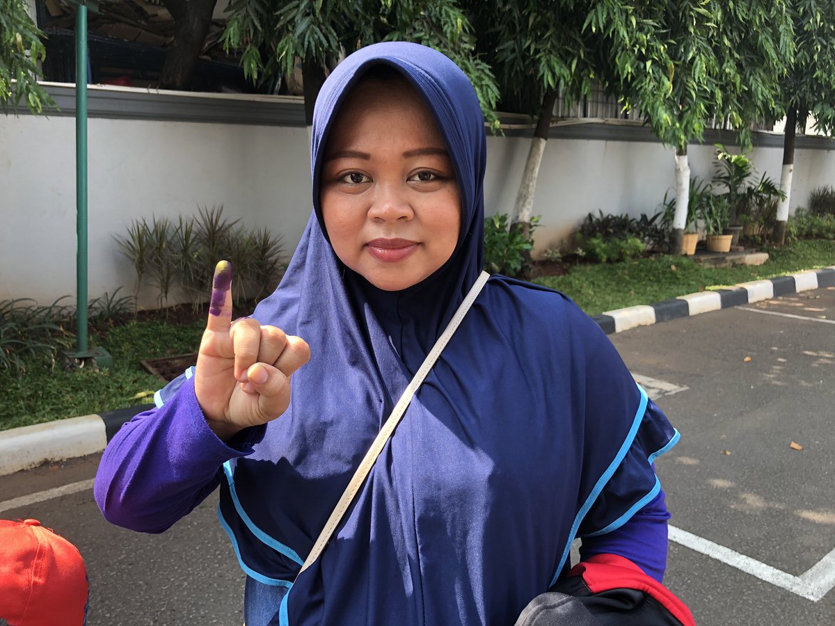 29-year-old Masruroh shows off her finger which has been dipped with indelible ink as proof that she has cast her vote in the Indonesian presidential and legislative elections.