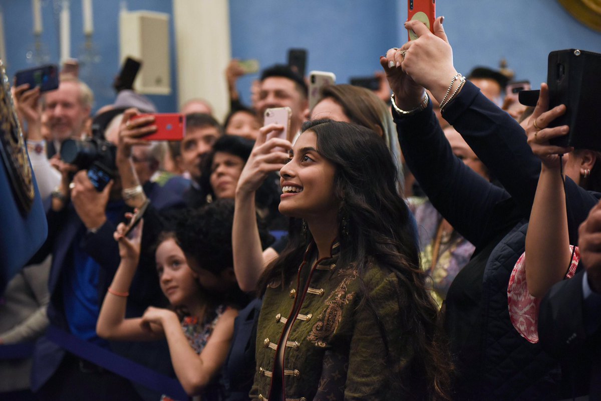 Woman looking up with people all around her with their phones up