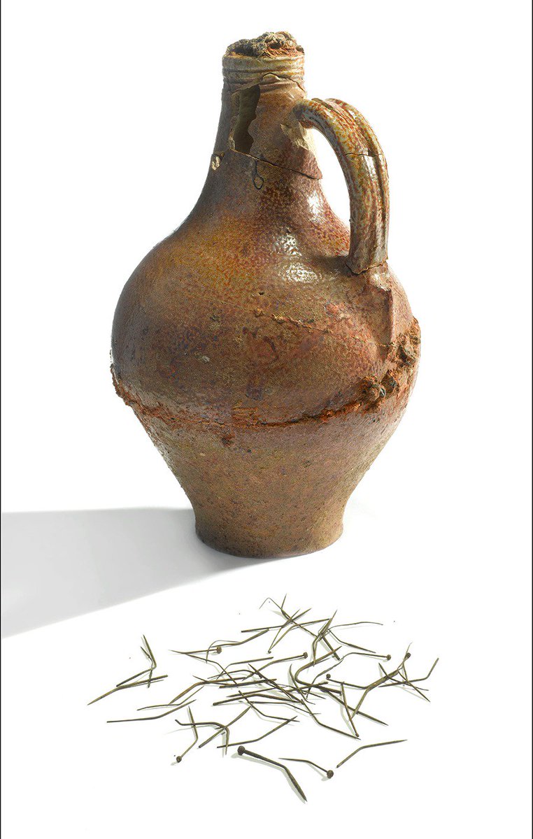 The Holywell ‘witch bottle’ and it’s contents of bent metal pins (c) MOLA