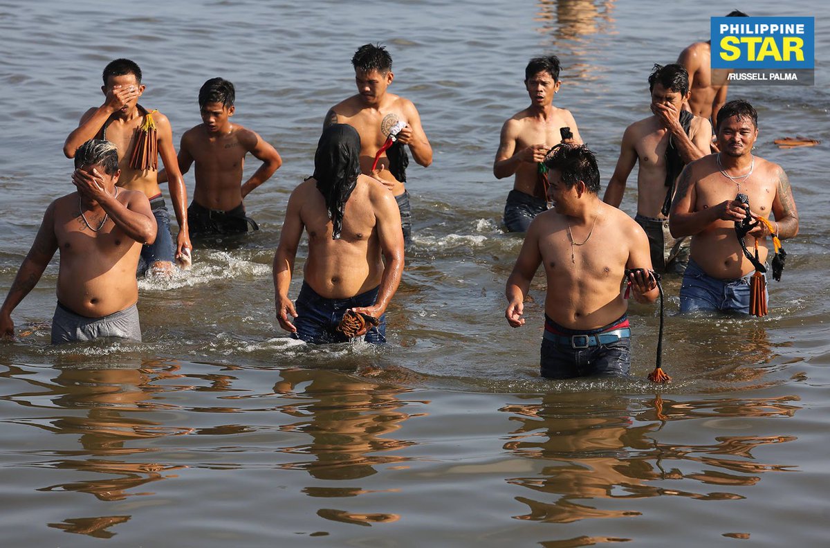 PhilippineStar's tweet photo. IN PHOTOS: In observance of Good Friday, devotees take a dip in the waters of Manila Bay in Ligtong, Rosario, Cavite after having their backs inflicted with multiple wounds. https://t.co/CAS3eRHnHa
