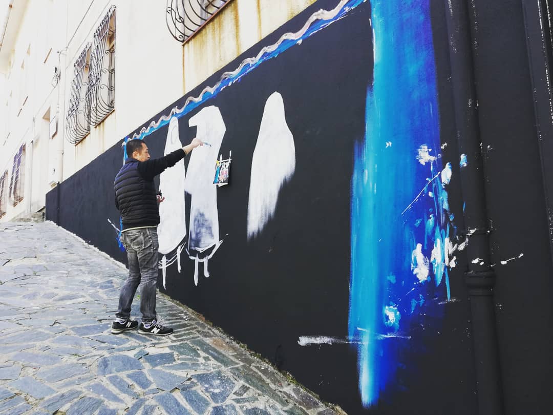 na_talloru's tweet photo. A #Tonara il muralista giapponese Akiko Okabe sta creando un'altra opera. 
#murales #barbagia #sardegna #peppinomereu #torrone #campanacci #StreetArt https://t.co/Uwjc9pD6IT