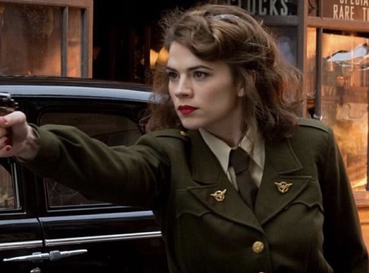 a woman in uniform kicking ass while wearing red lipstick... iconic literally iconic