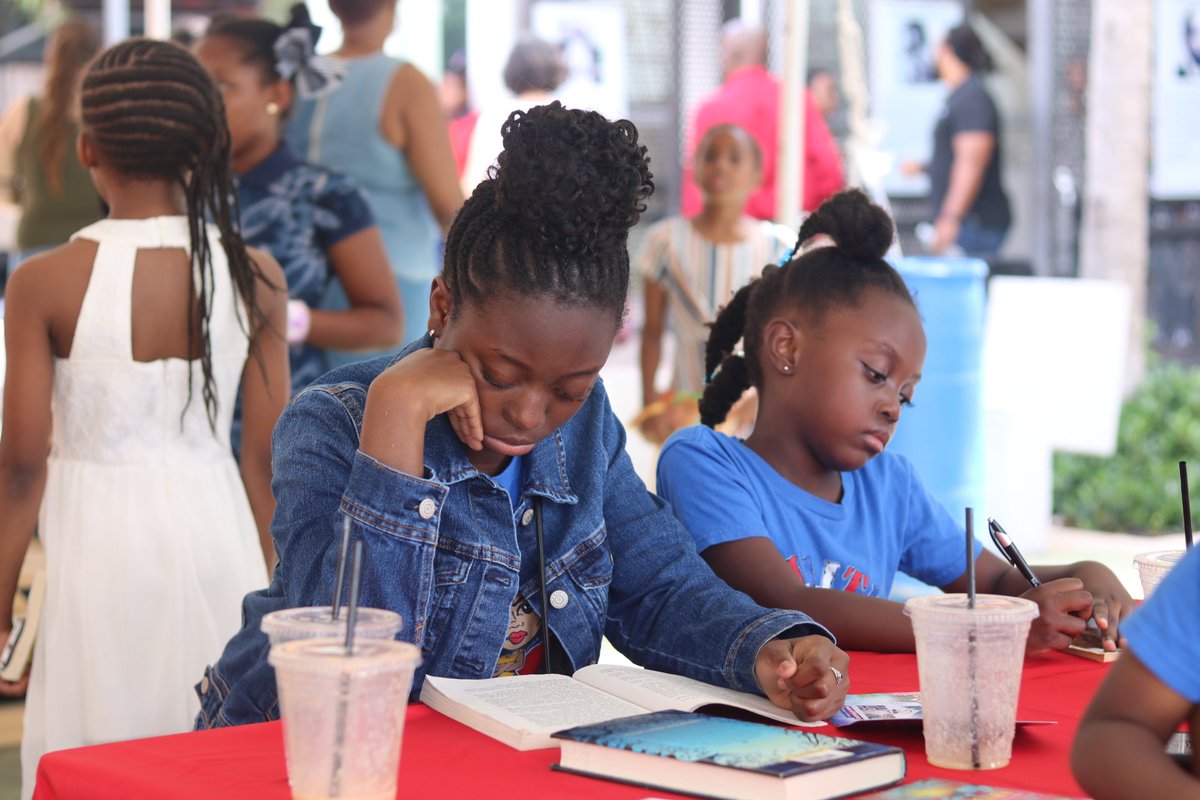 SuzeGuillaume's tweet photo. This is my favorite photo from the #LittleHaitiBookFestival. I captured this image after the young lady picked up her book from the #ReadToLearn table and went to sit with her family. This is where the magic happens. #proud #WeHaveToGoBack #ReadToLearn #freebooks @MiamiBookFair https://t.co/r70fxnUAKB