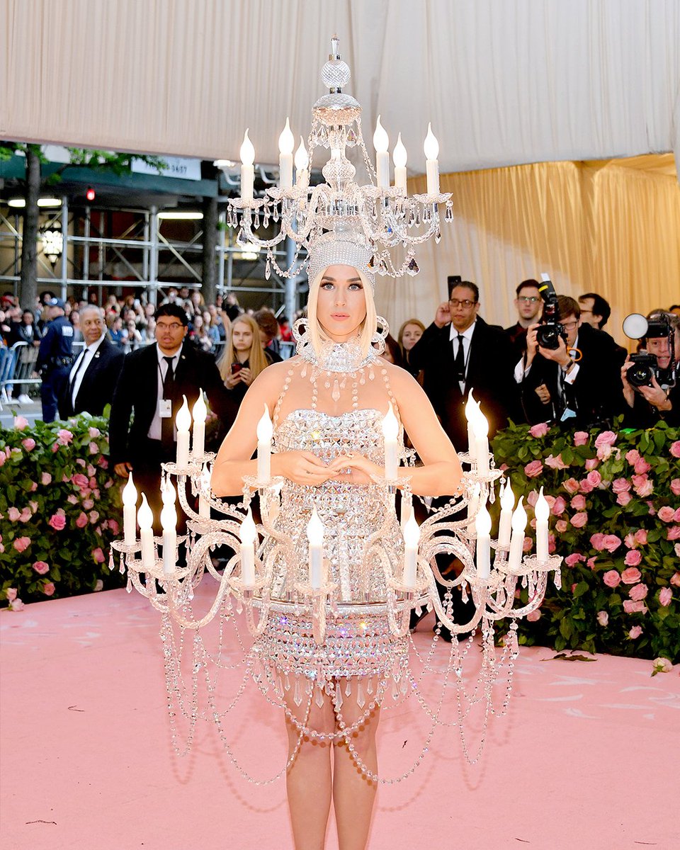 swarovski's tweet photo. Glow-getter. Pop princess @katyperry illuminates the #MetGala red carpet in a @moschino chandelier dress featuring crystal stones, pendants and functional light components from @swarovski. https://t.co/X4QSJiJh7O