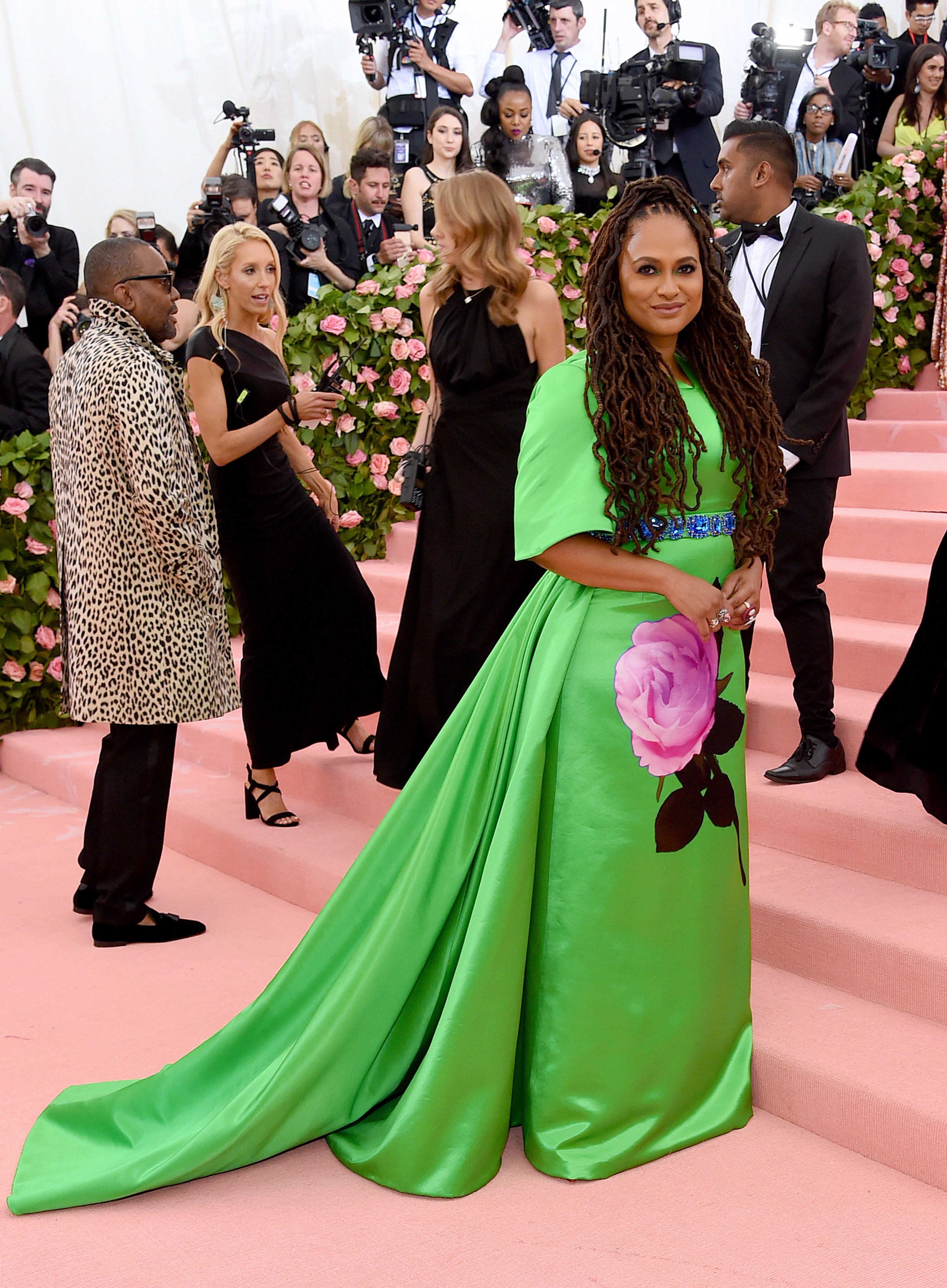 PRADA on X To the MetGala Ava DuVernay wears a custom Prada emerald green duchesse gown accented with a violet and pink oversized printed rose and blue crystal belt red satin bow