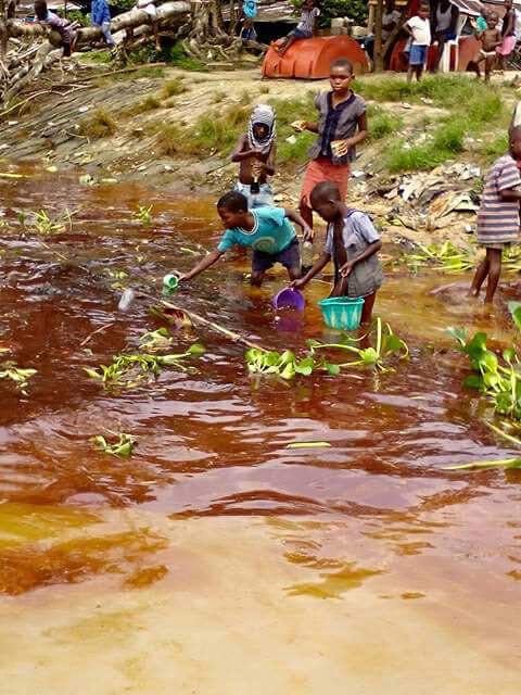MercyEbute's tweet photo. What you see vividly in the picture are kids scooping crude oil filled water, the drinking water is polluted, this is posing so much danger to their health.....#NDCleanUp #FixOurOil #NNRCChats https://t.co/KhQK2EmmBc