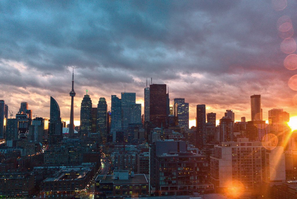 GlobeSunset's tweet photo. It’s a #sunset with the sun still peeking through the skyline! Lens spots! #toronto https://t.co/SpReW0pxik