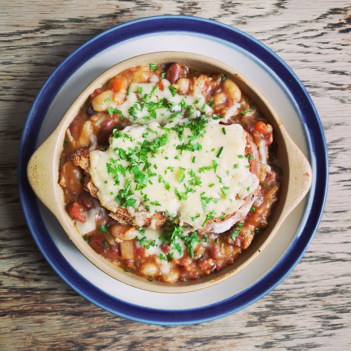 Drizzly weather calls for a hearty lunch. A bowl of slow cooked pork and beans topped with a crunchy slab of cheese on toast and baked in the oven will do the trick!