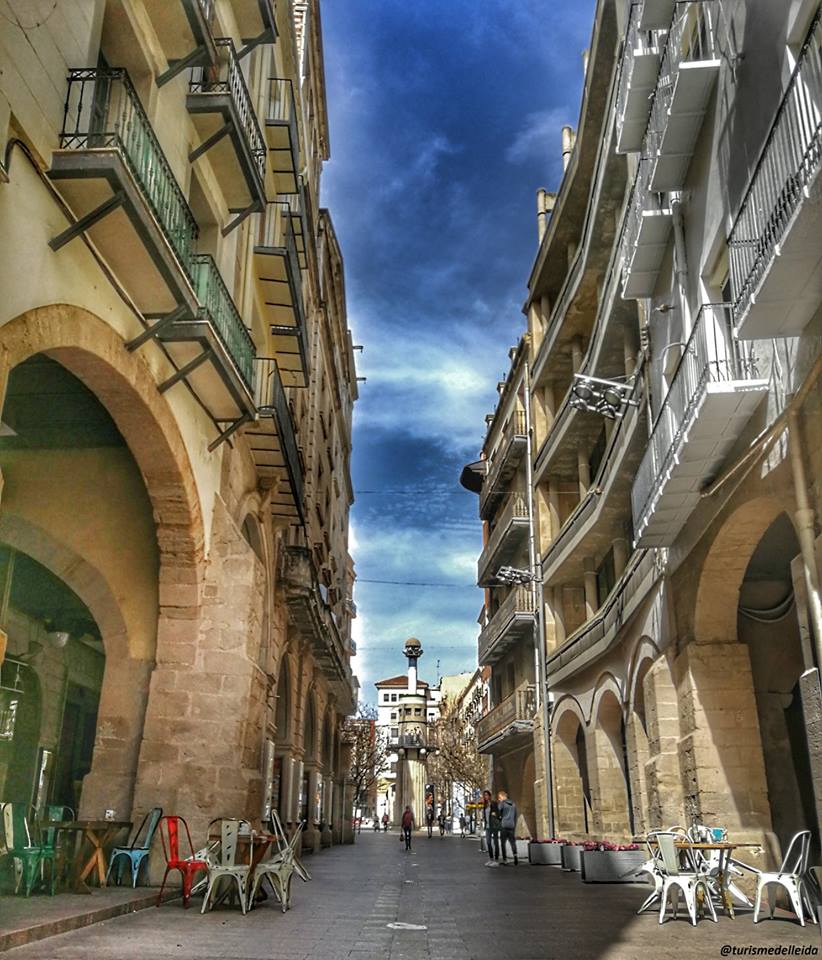 Foto del carrer major al seu pas pels porxos. Al fons, la plaça de Sant Joan.