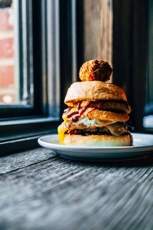 When you're located in a former jail, it makes sense to name your PEI Burger Love after a couple of famous outlaws!
The Clyde
Bourbon peach bacon jam
Island beef
Smoked cheddar
Back bacon
Bavarian beer mustard
Black garlic ketchup
Fried egg
Onion rings
Scotch egg skewer