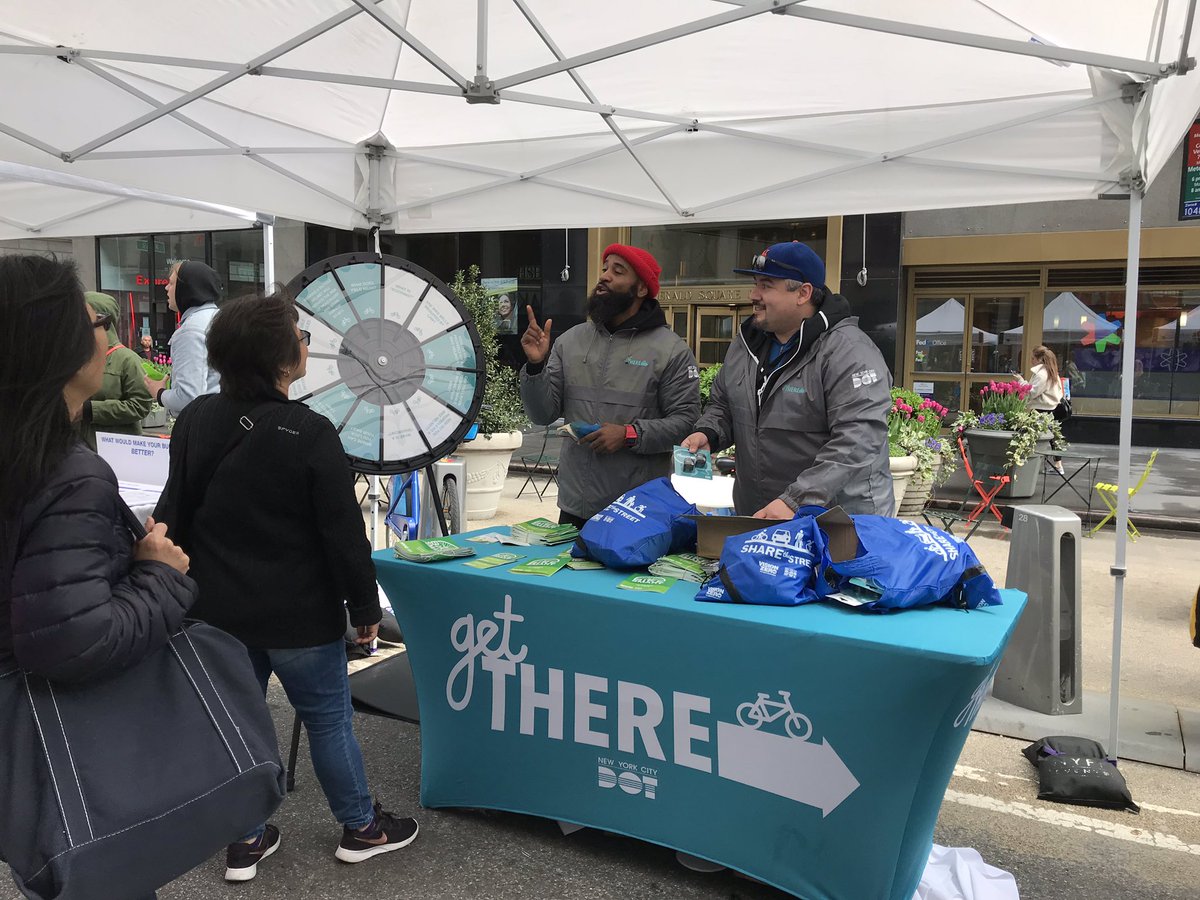 People stand behind a table that says “Get There” with a bike symbol