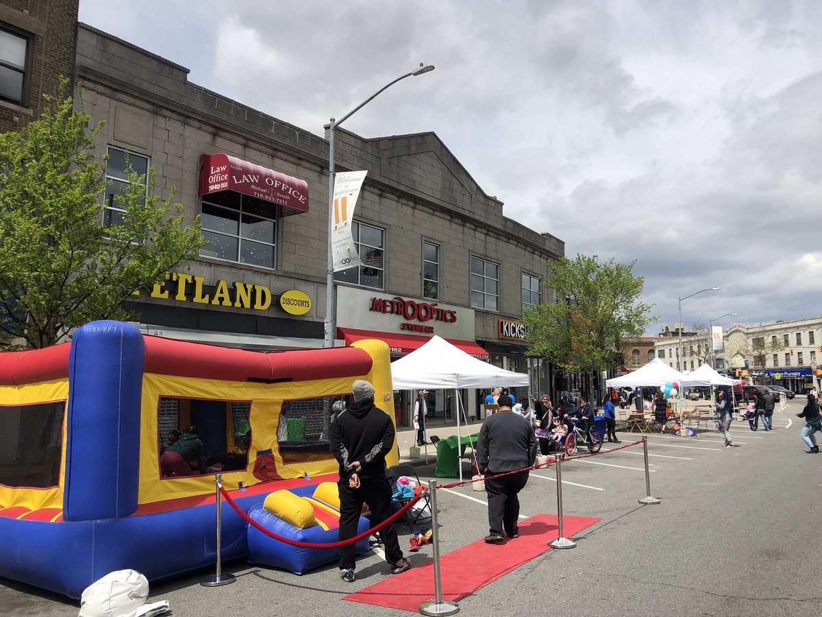 A bouncy house and tents are seen in a street closed to cars