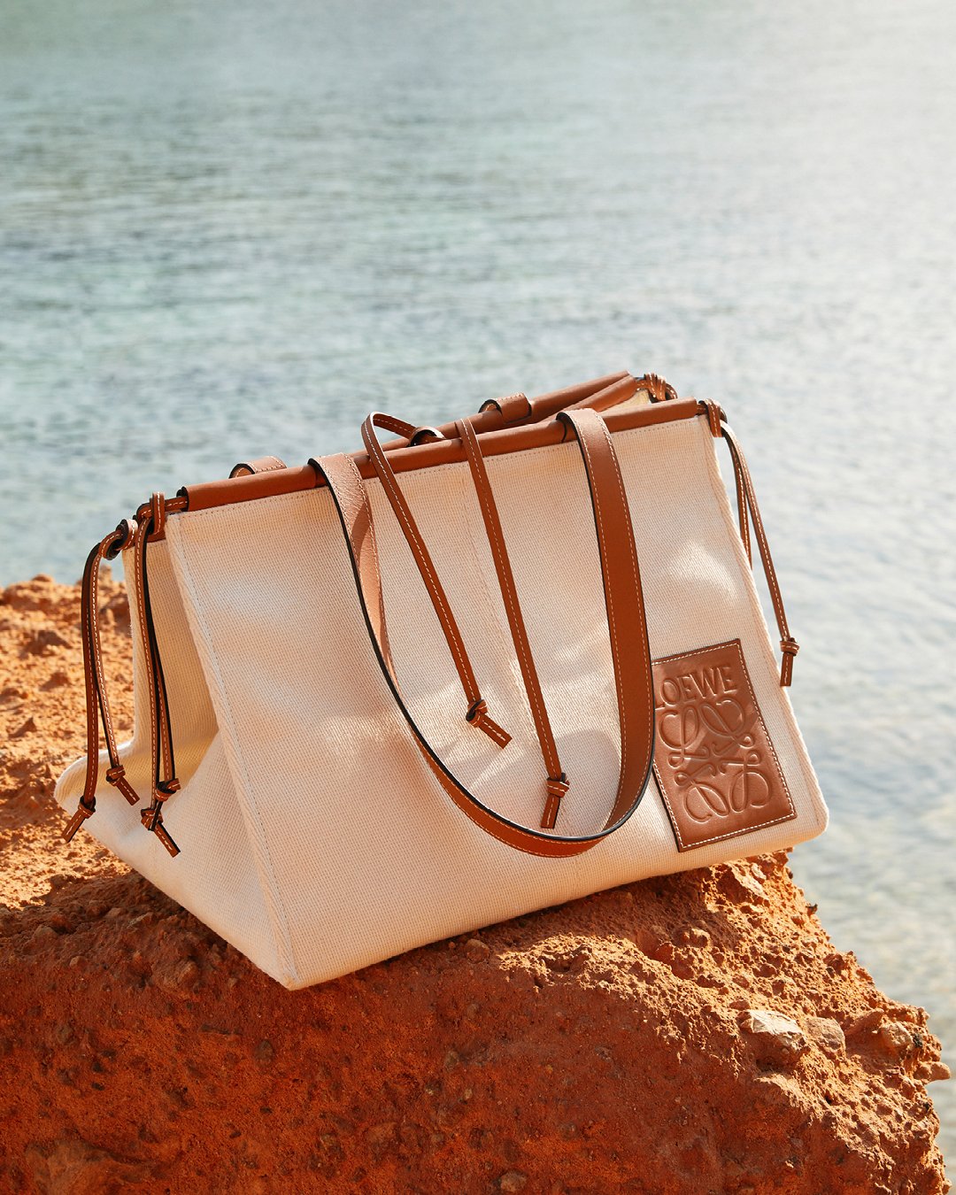 LOEWE on X Cushion Bag is introduced for Paula s Ibiza and inspired by LOEWE s signature home decor cushion design flourishing with bended sides and knotted leather straps at the edges. LOEWEpaulas LO...
